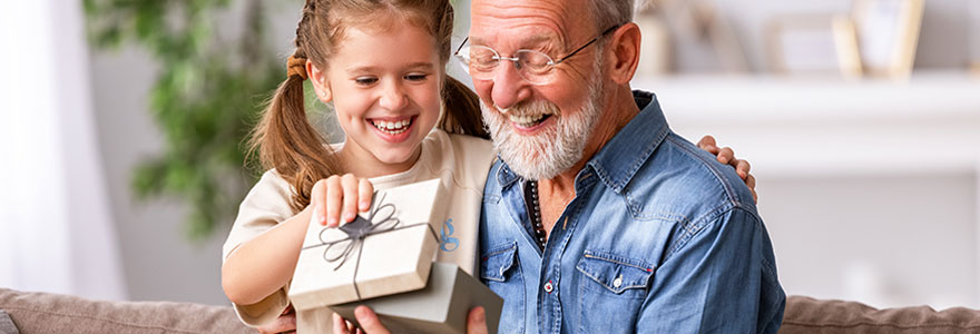 Older man opening gift box from young girl